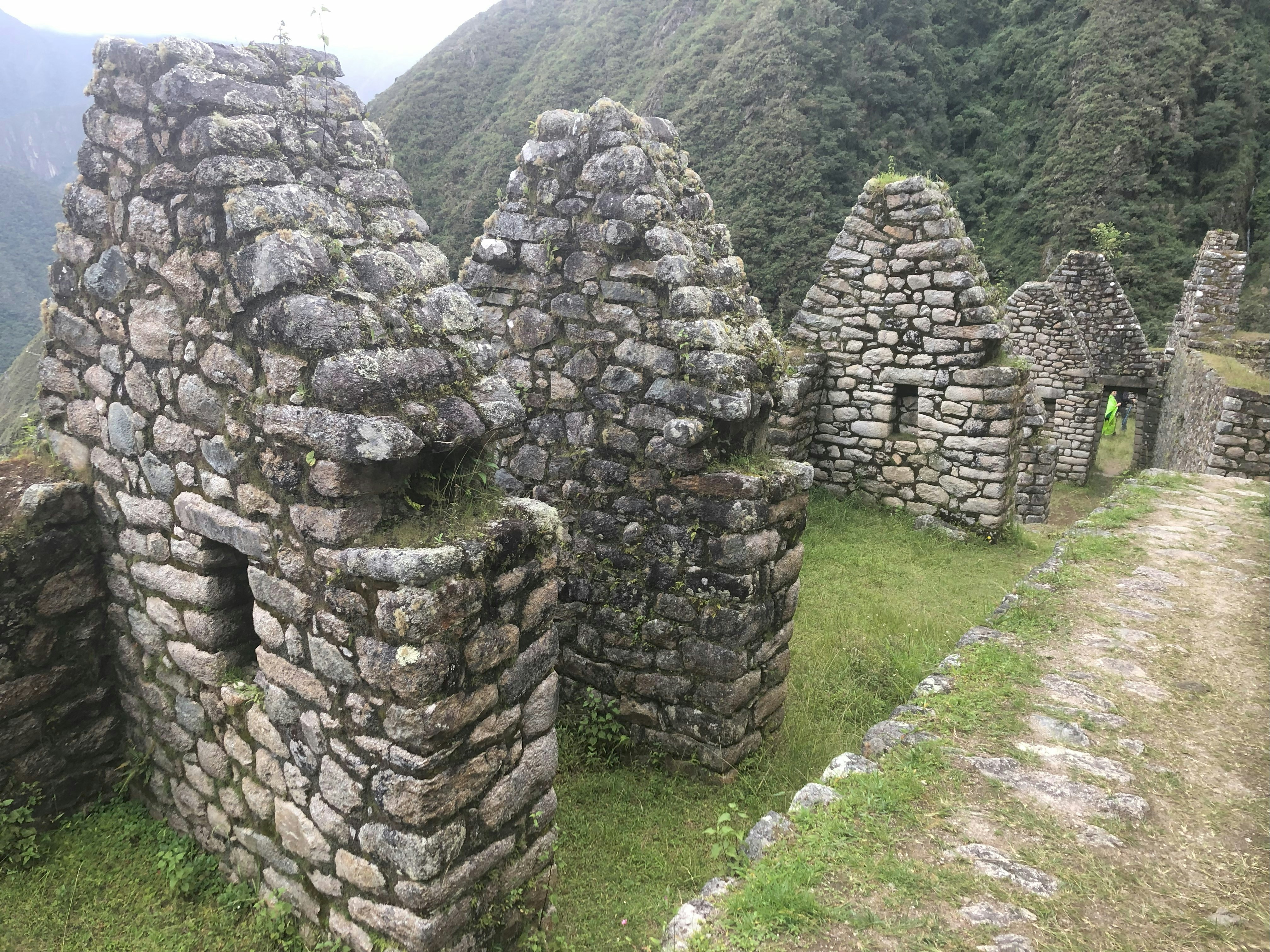 A group of stone buildings sitting on top of a lush green hillside
