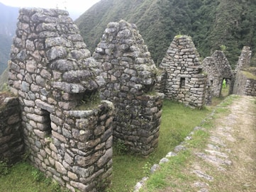 A group of stone buildings sitting on top of a lush green hillside