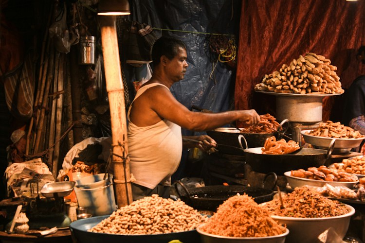 A traveler checking a handwritten receipt and counting local currency at an outdoor café