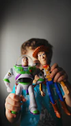 A young boy holding a toy buzz lightyear and buzz lightyear buzz lightyear
