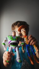 A young boy holding a toy buzz lightyear and buzz lightyear buzz lightyear