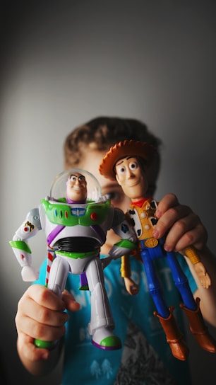 A young boy holding a toy buzz lightyear and buzz lightyear buzz lightyear