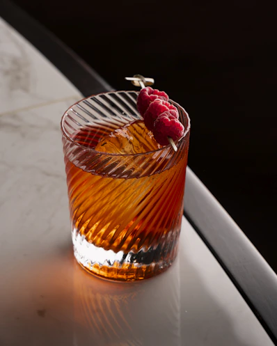 A glass with a raspberry in it sitting on a table