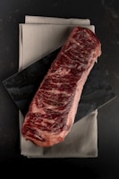 A piece of steak sitting on top of a napkin