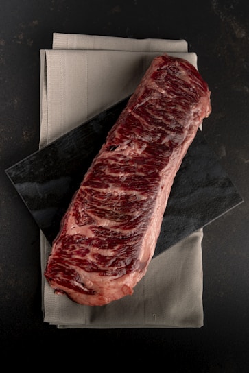 A piece of steak sitting on top of a napkin