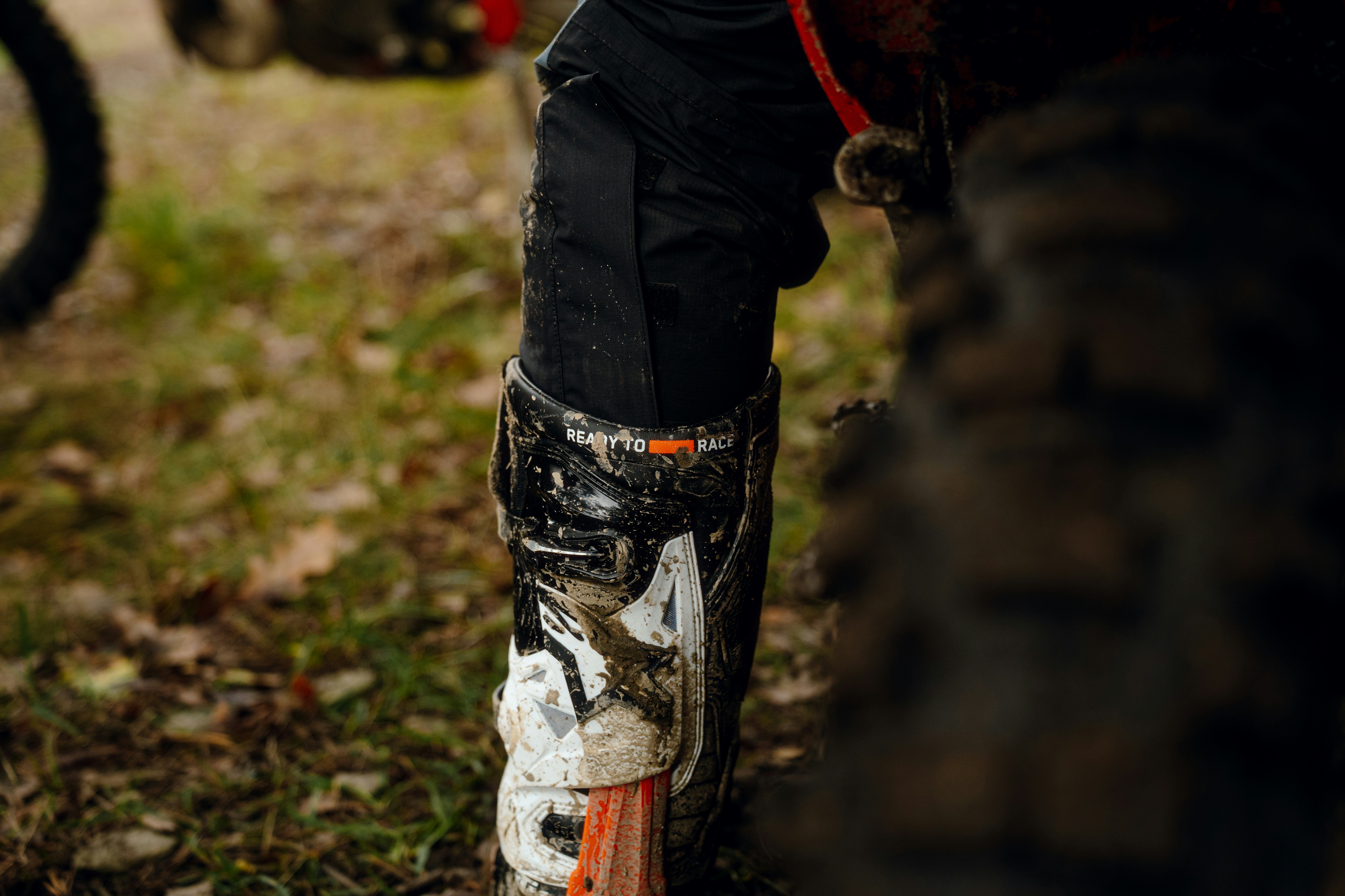 A close up of a person standing next to a dirt bike