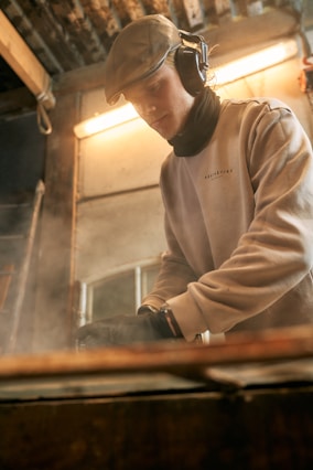 A man wearing headphones is working on a piece of equipment