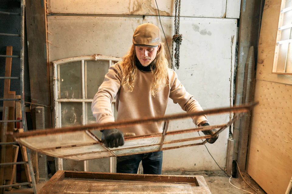 A woman working on a piece of furniture in a workshop