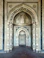 A long hallway leading to an ornate doorway