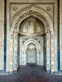 A long hallway leading to an ornate doorway