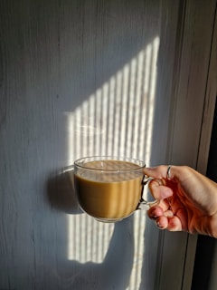 A person holding a cup of coffee in their hand