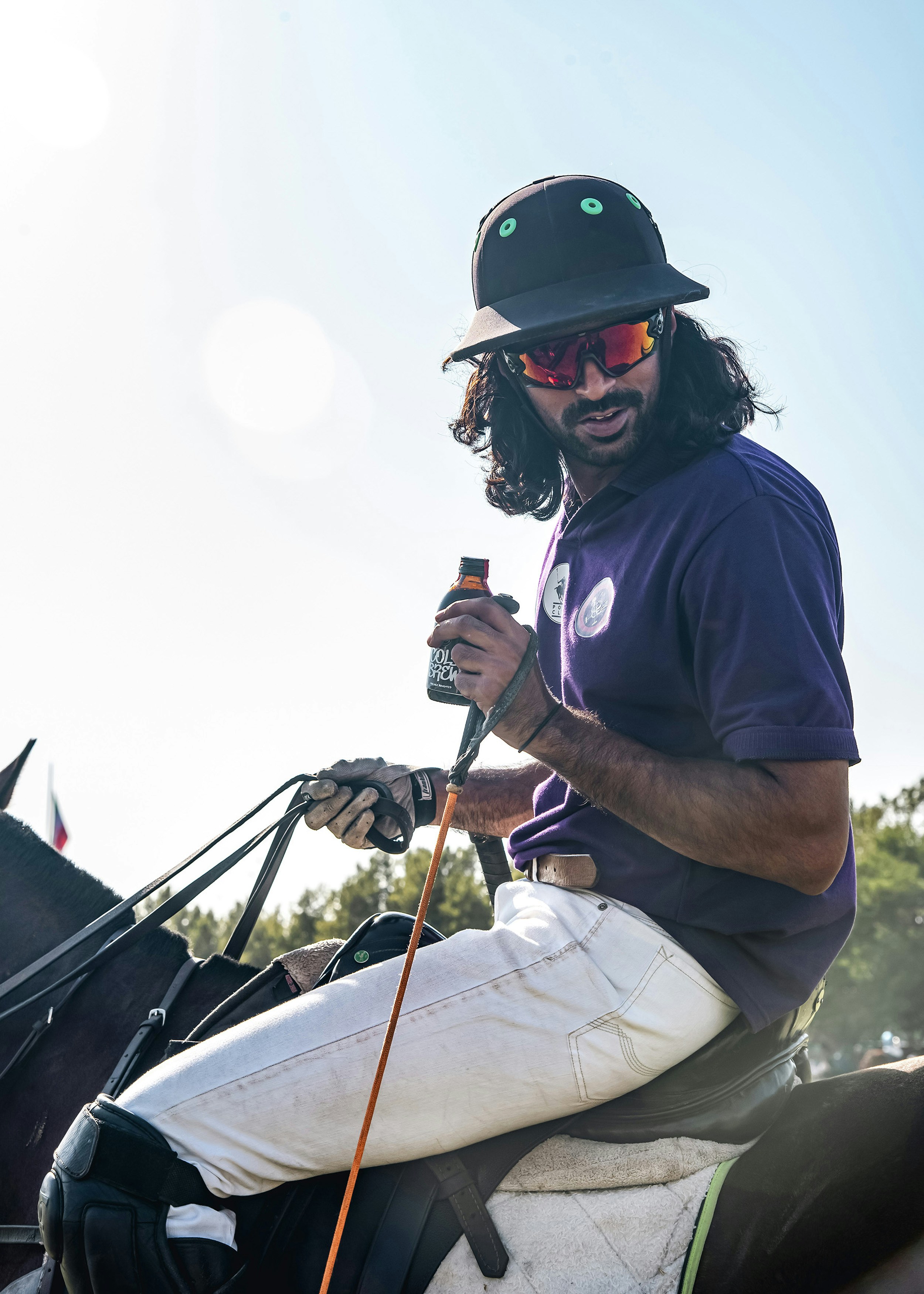 Un hombre cabalgando a lomos de un caballo negro