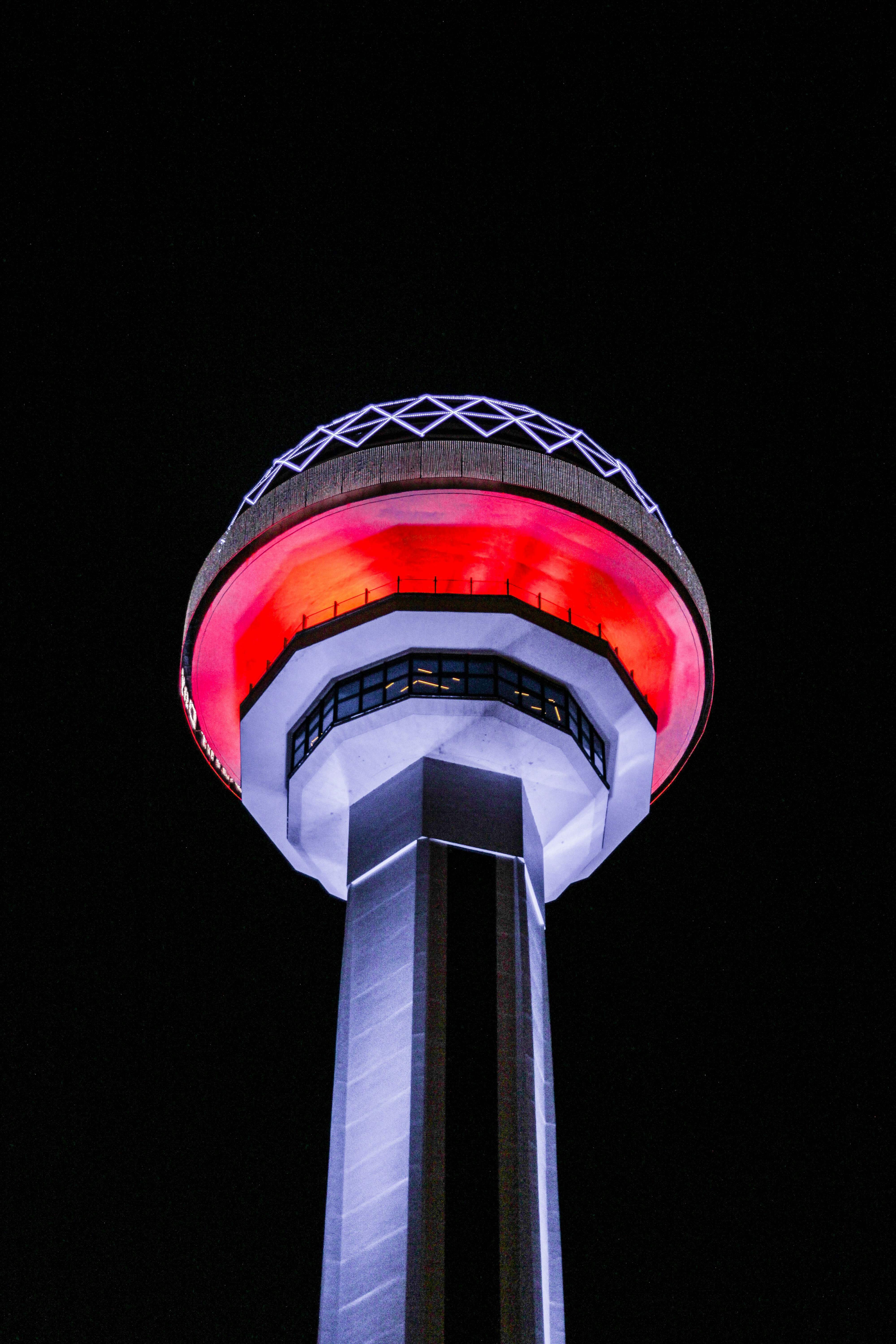 A tall tower with a red light on top of it