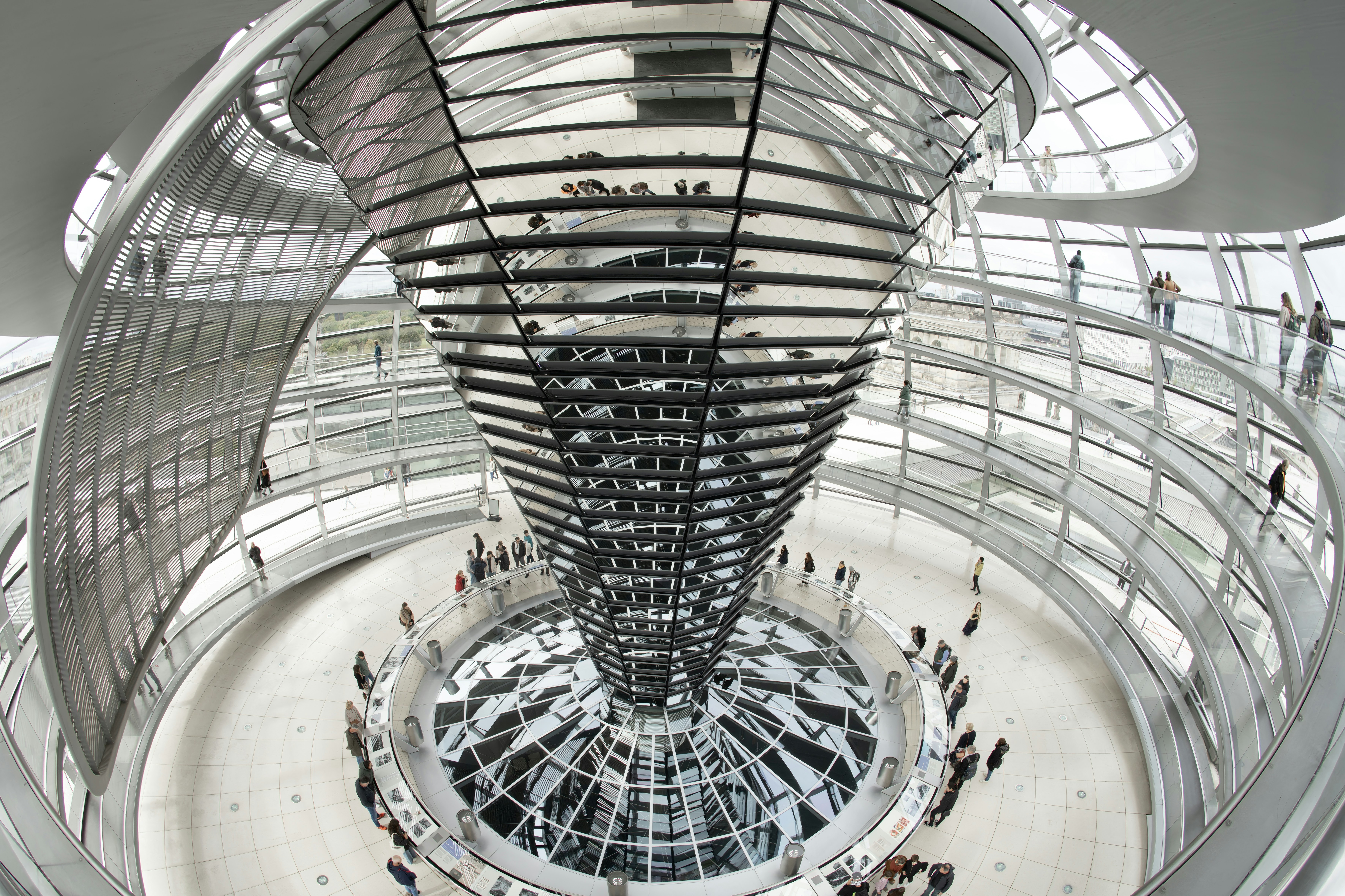 A spiral staircase inside of a building with lots of people