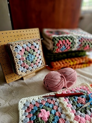 A crocheted blanket and a crochet kit on a bed