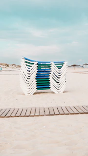 A row of chairs sitting on top of a sandy beach