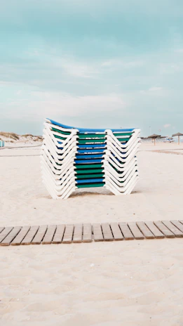 A row of chairs sitting on top of a sandy beach