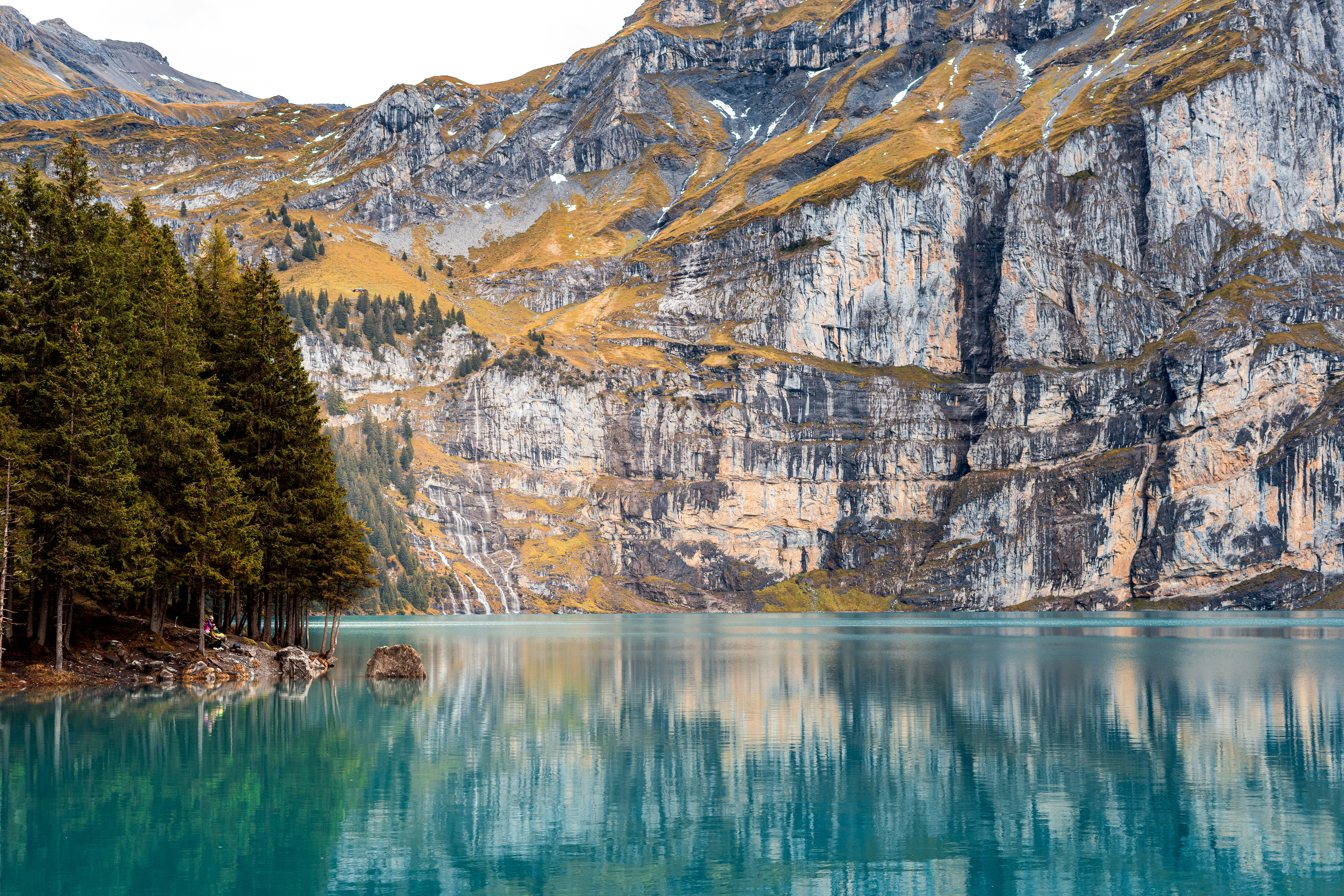 A body of water surrounded by mountains and trees, 