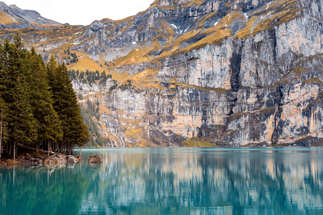 A body of water surrounded by mountains and trees,
