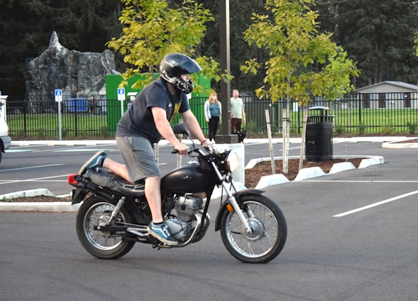 A man riding a motorcycle in a parking lot