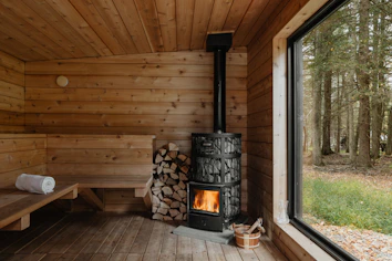 A wood burning stove inside of a wooden cabin