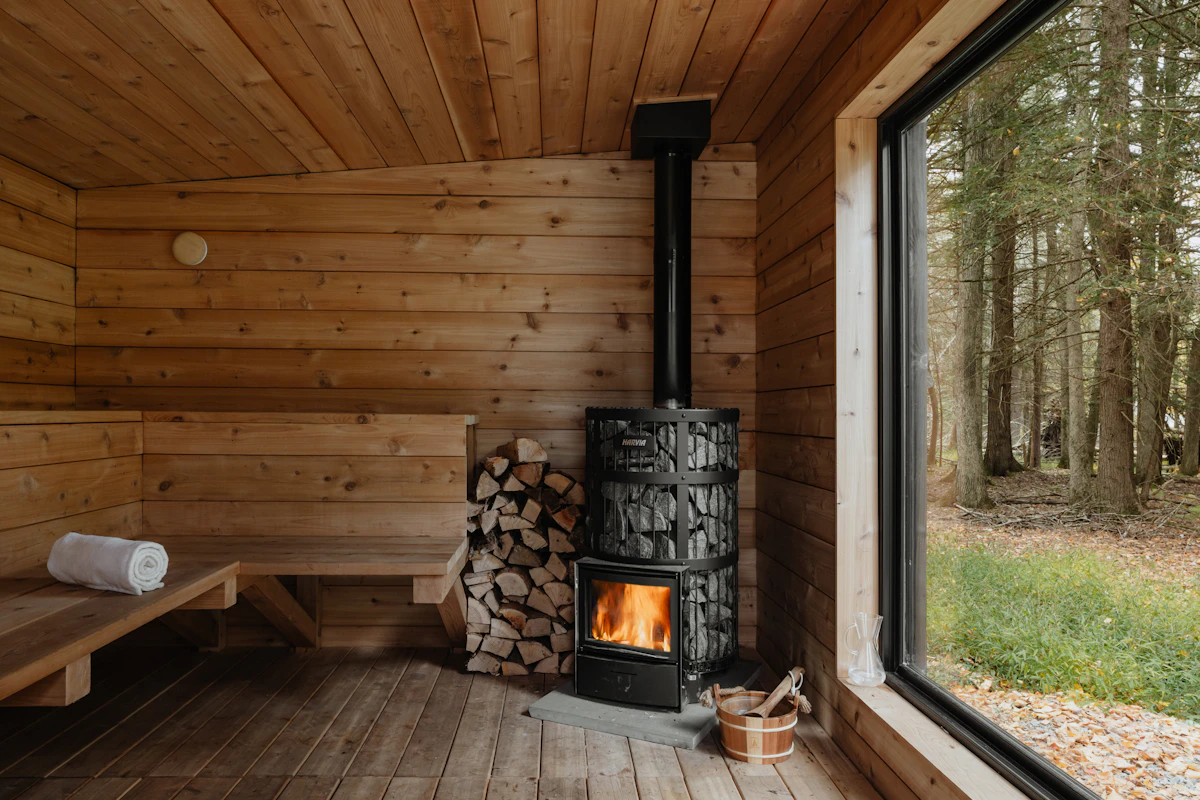 Dřevěná sauna s kamny a výhledem do lesa