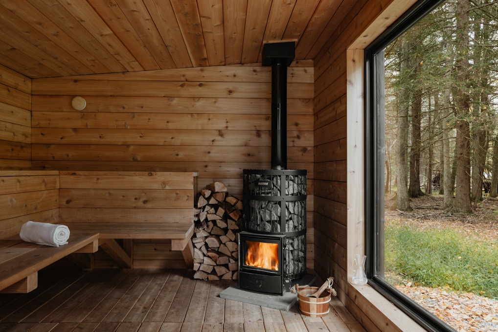 A wood burning stove inside of a wooden cabin