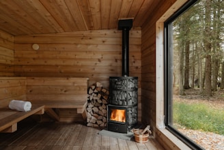 A wood burning stove inside of a wooden cabin