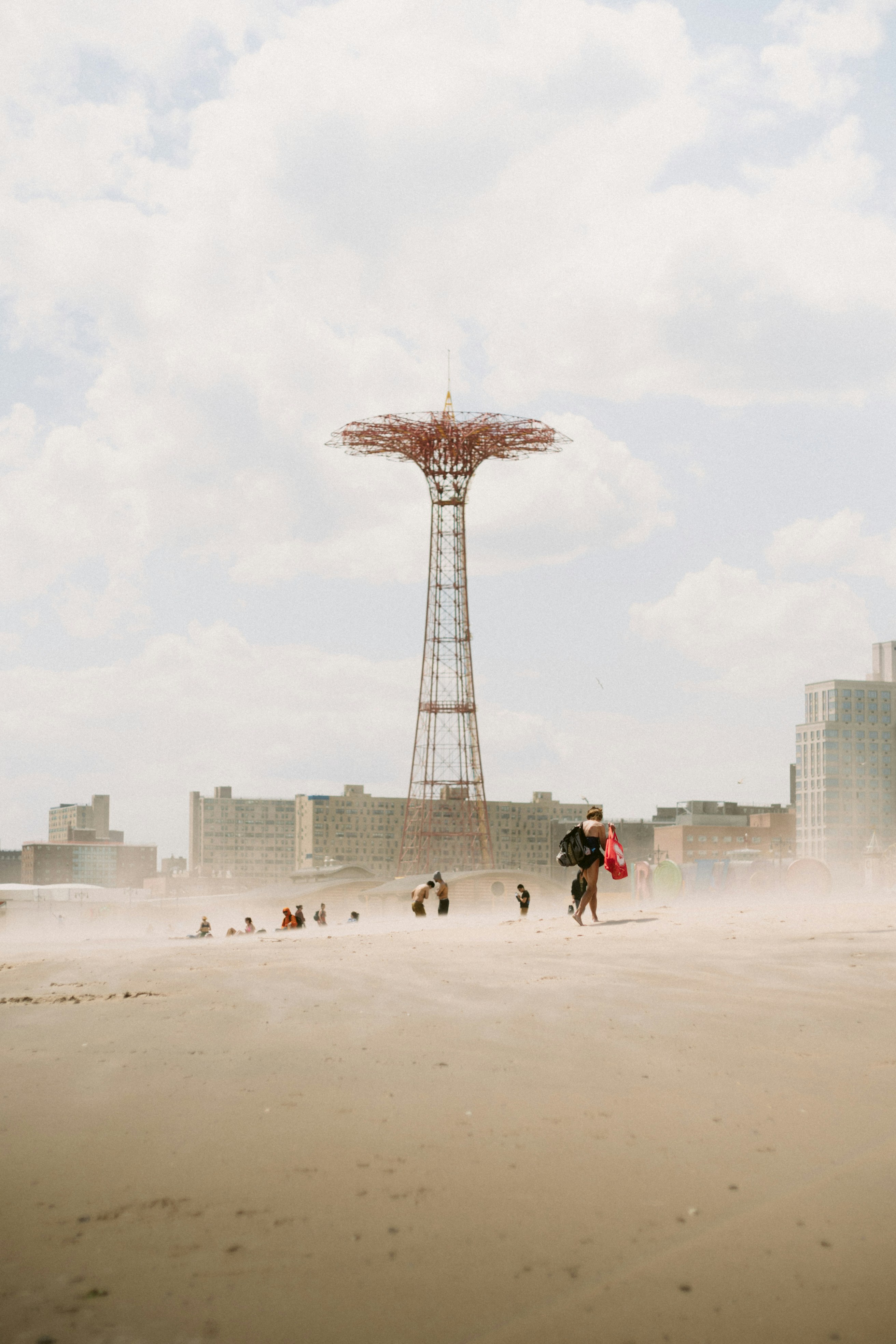 A group of people standing on top of a sandy beach