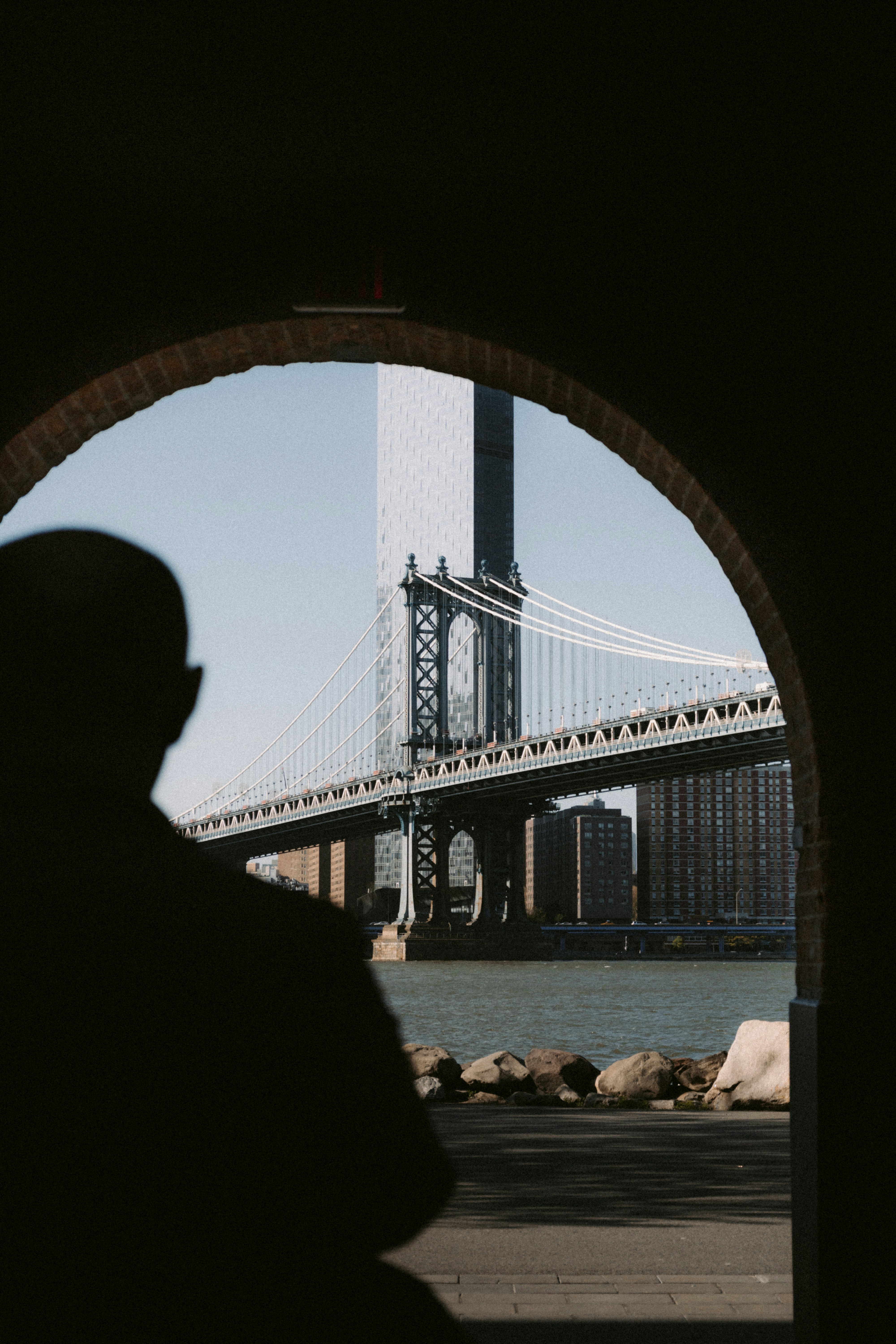 A man standing in front of a bridge