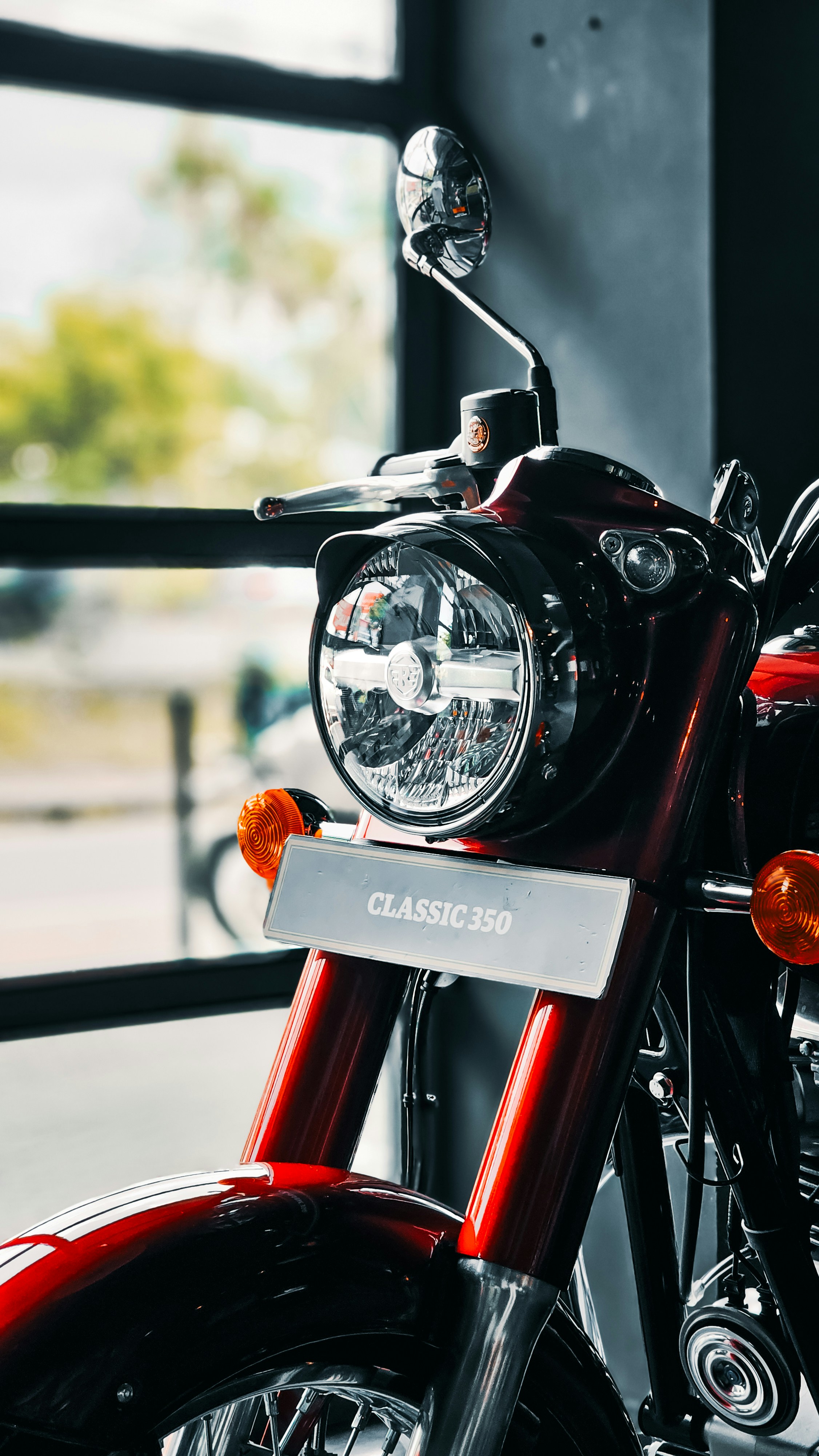A red motorcycle parked in front of a window