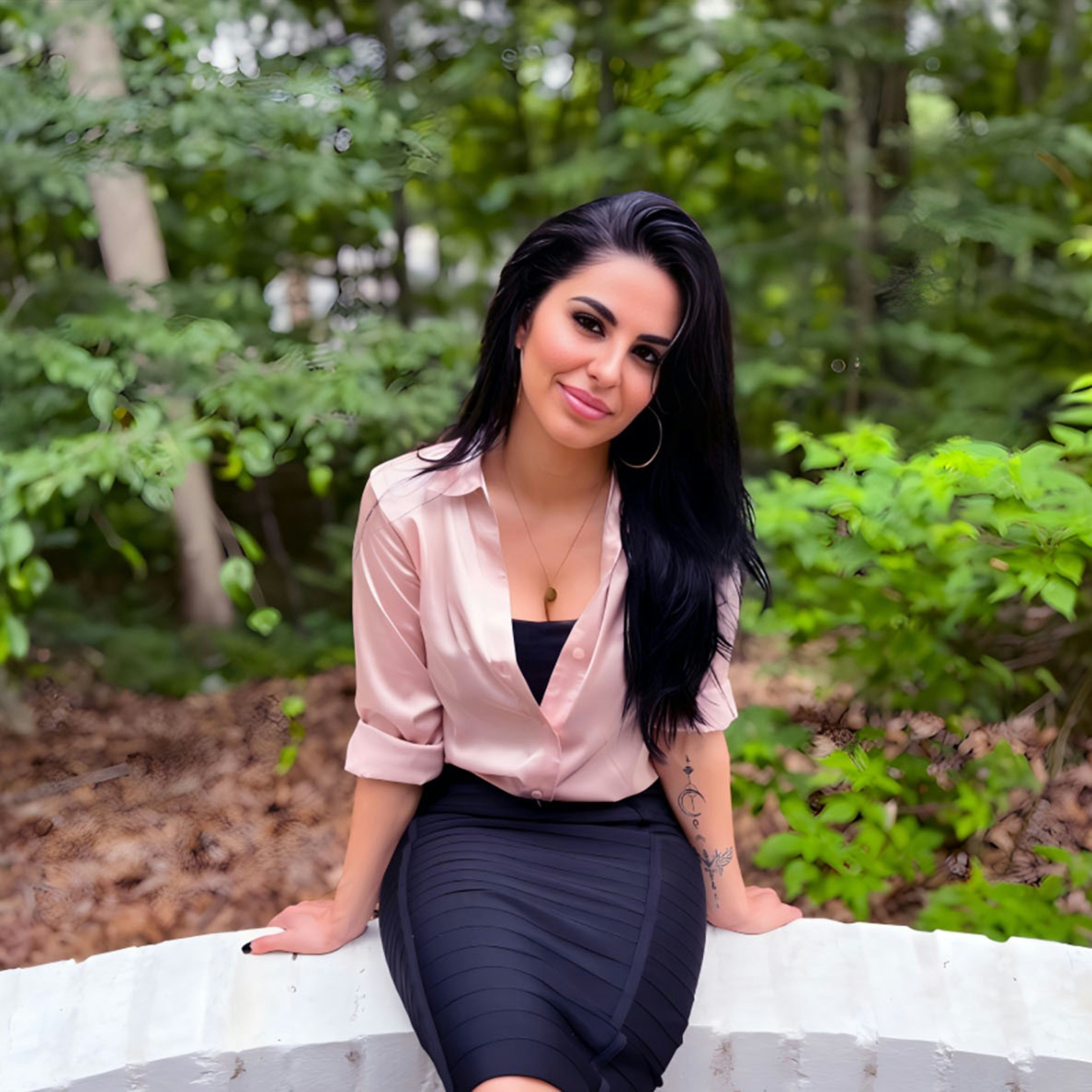 A woman sitting on a wall in a skirt
