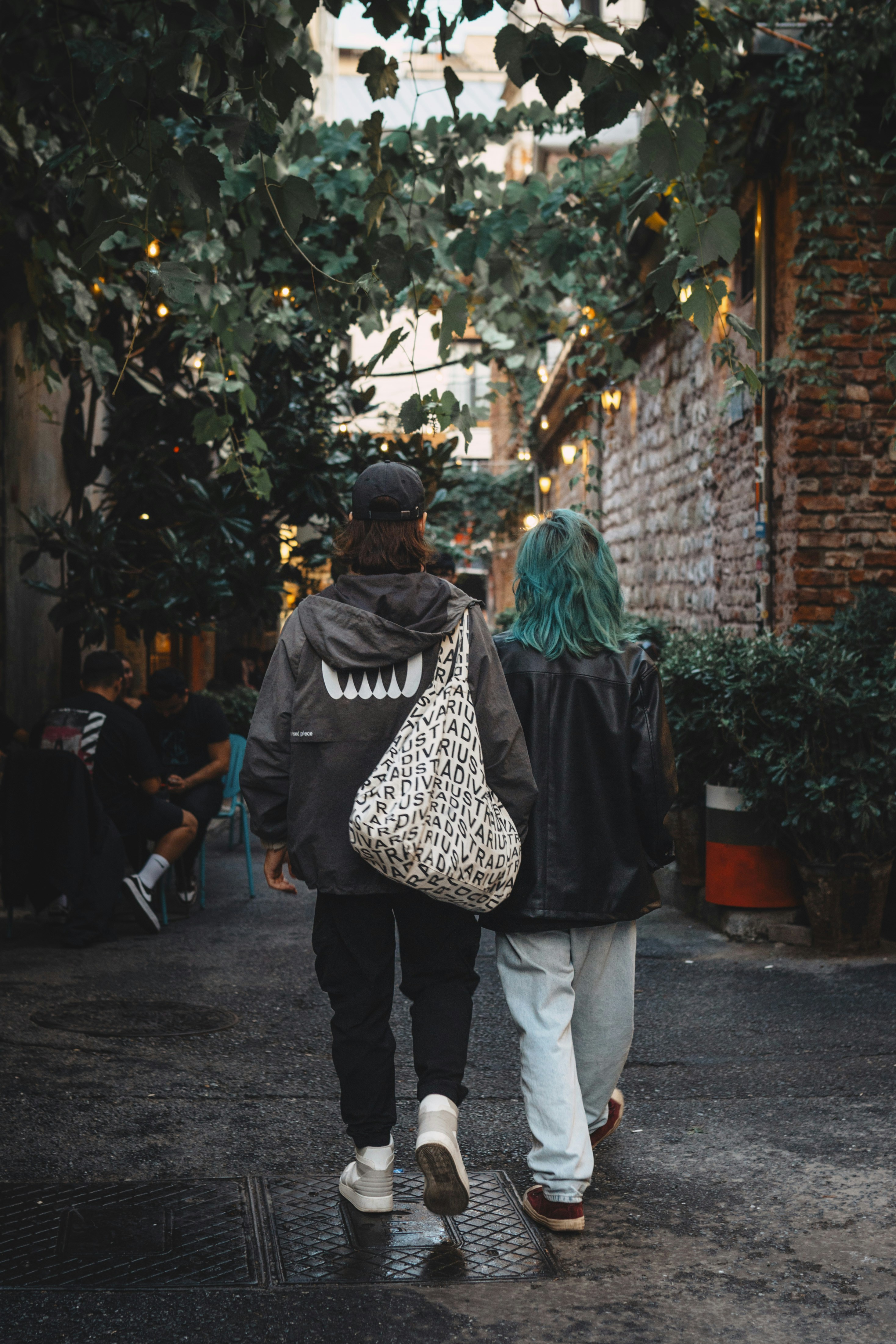 A couple of people walking down a street