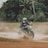 A man riding a motorcycle through a puddle of water