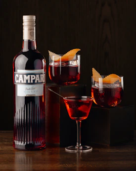 A bottle of campari next to a glass of wine