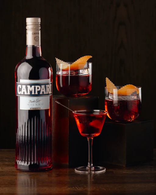 A bottle of campari next to a glass of wine