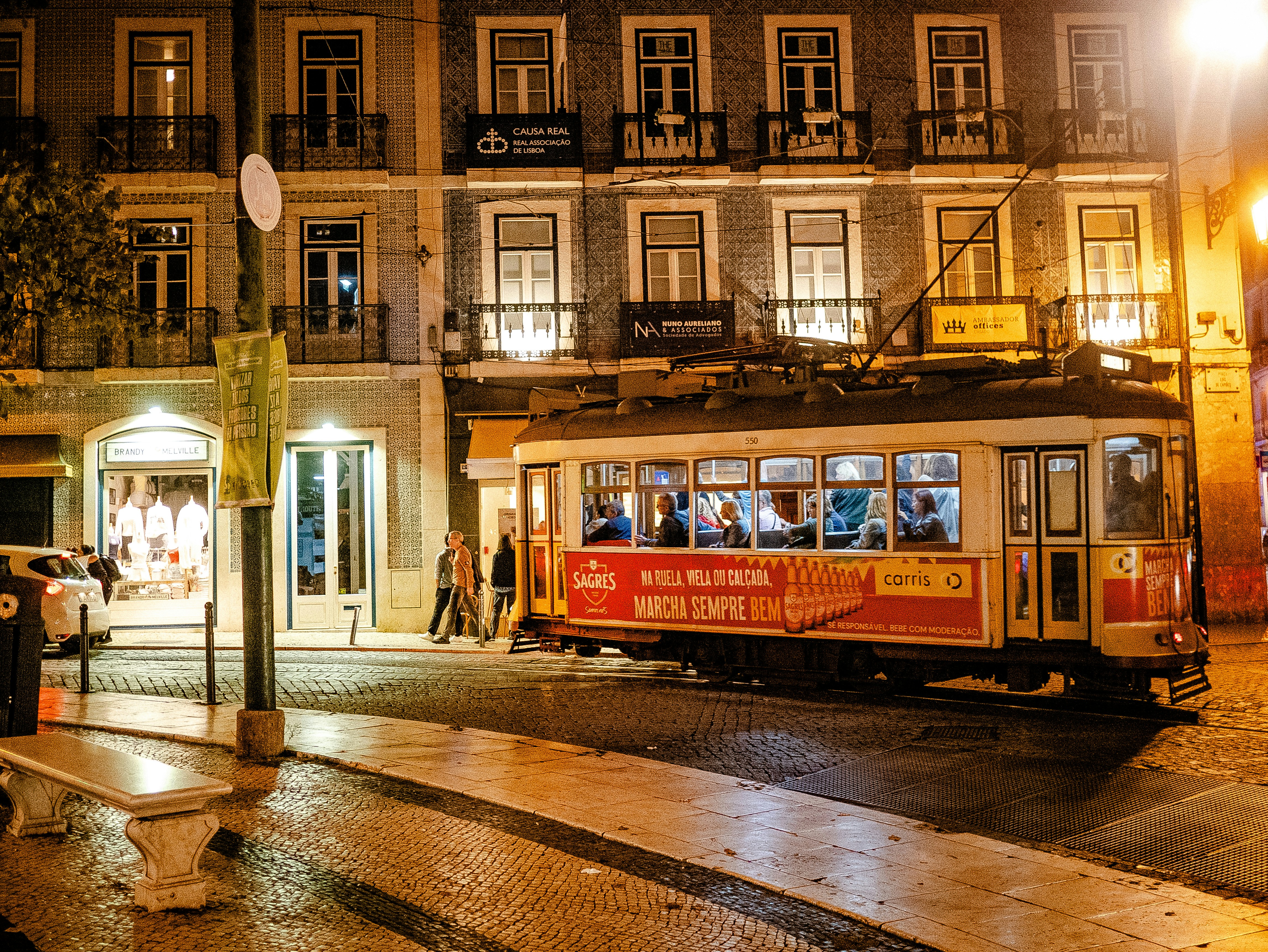 A Lisbon tram on a city street at night