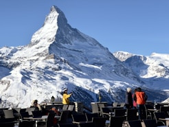 A group of people standing on top of a snow covered mountain