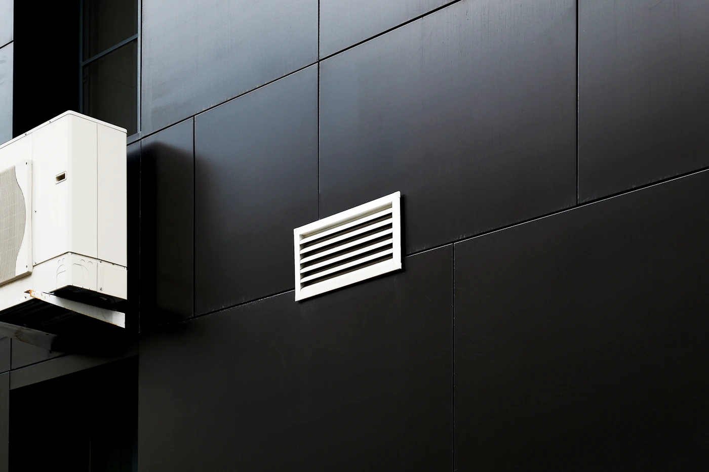 Air conditioning equipment and ventilation on a dark exterior wall