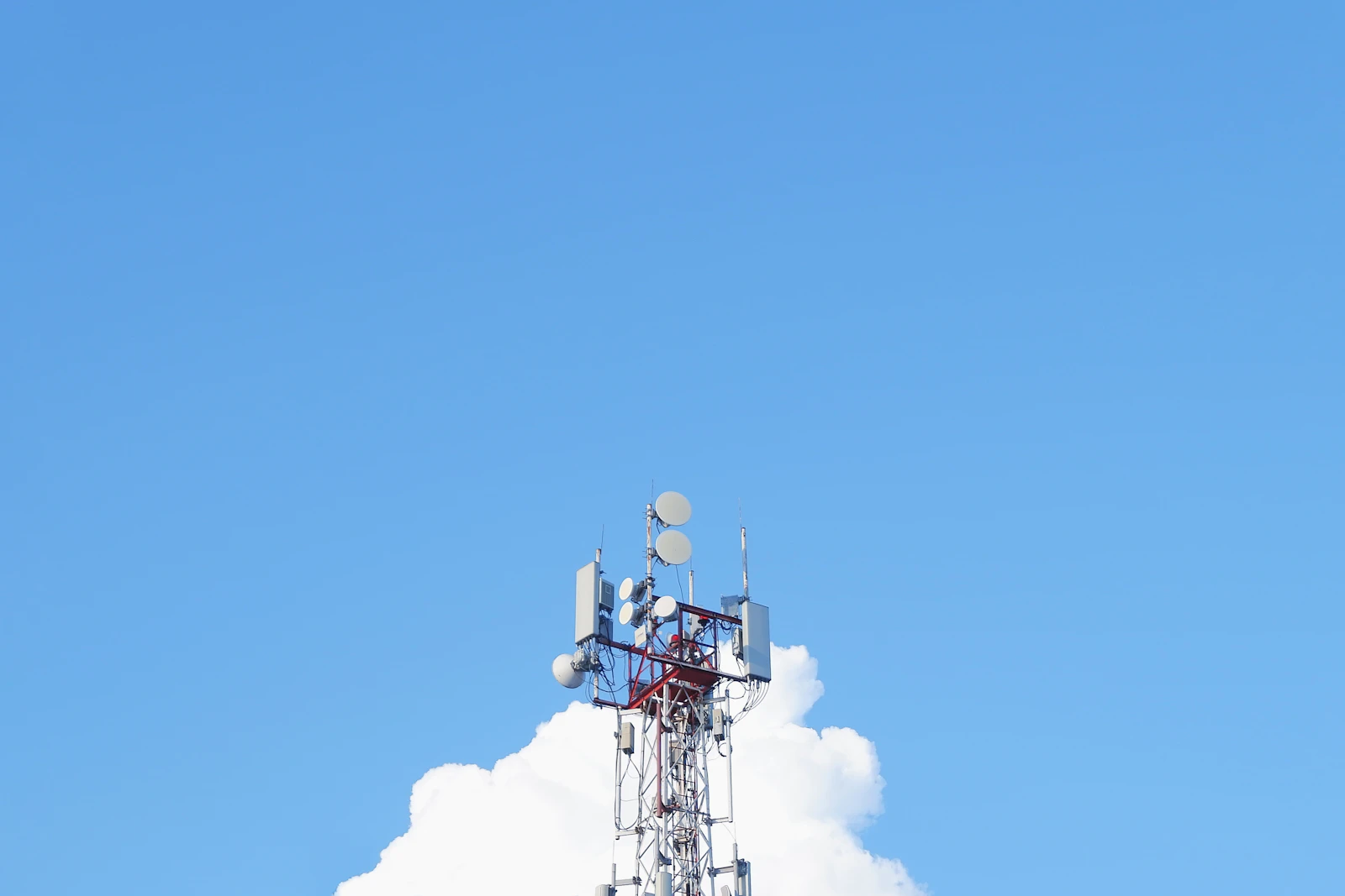Mobile network tower transmitting cellular signal over the city