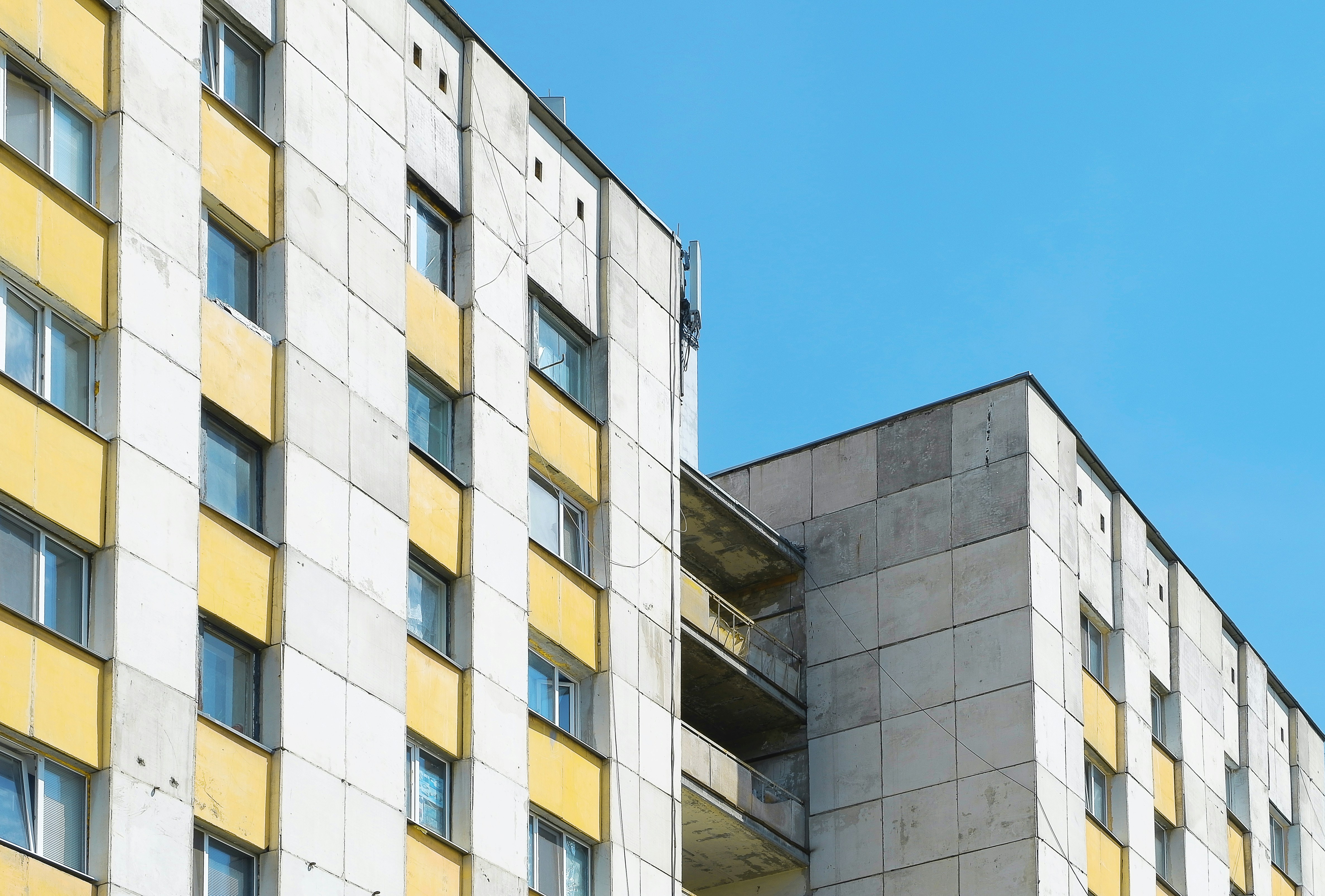 信号機の隣にある黄色と白の背の高い建物