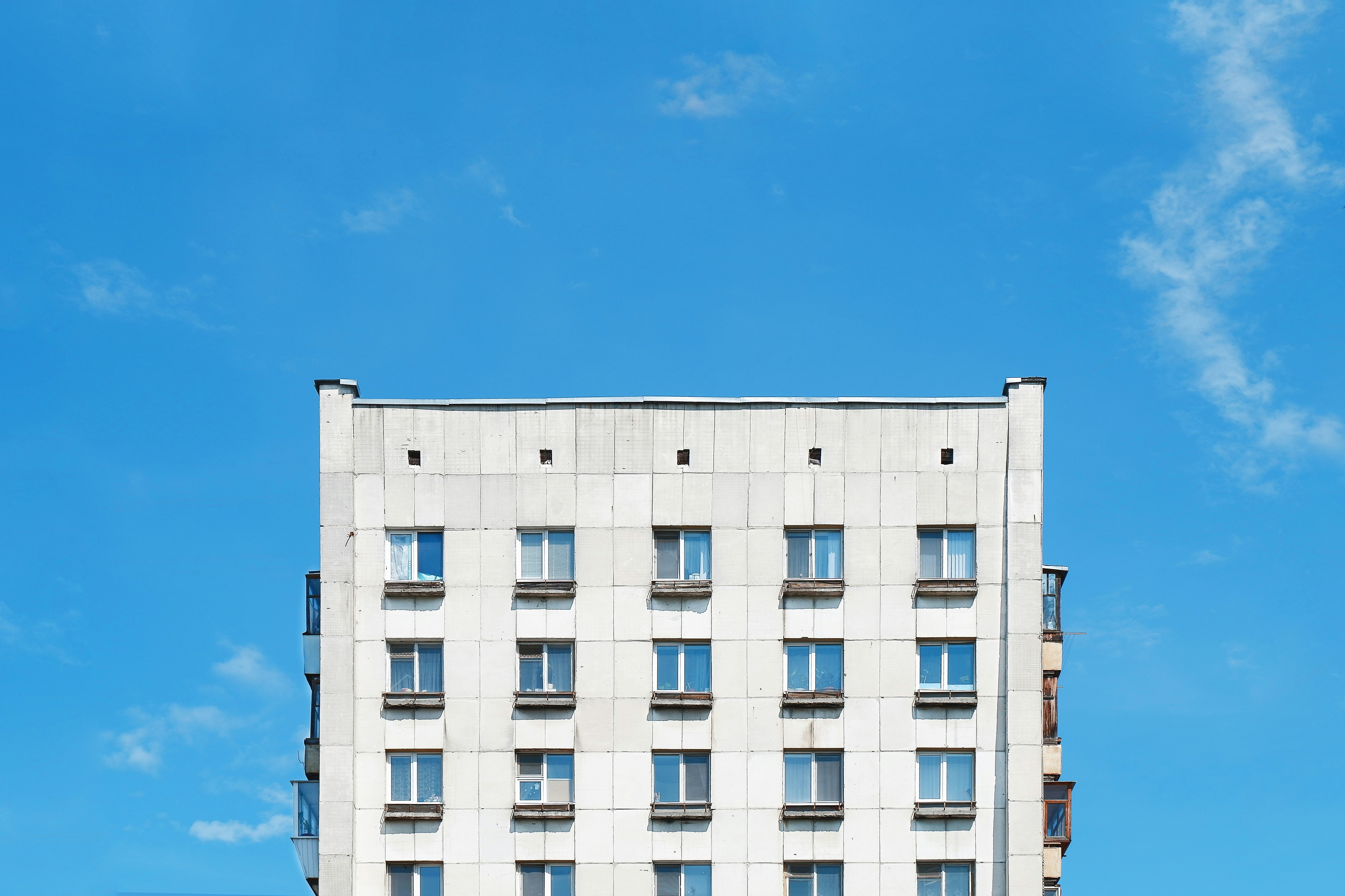 A tall white building sitting on the side of a road