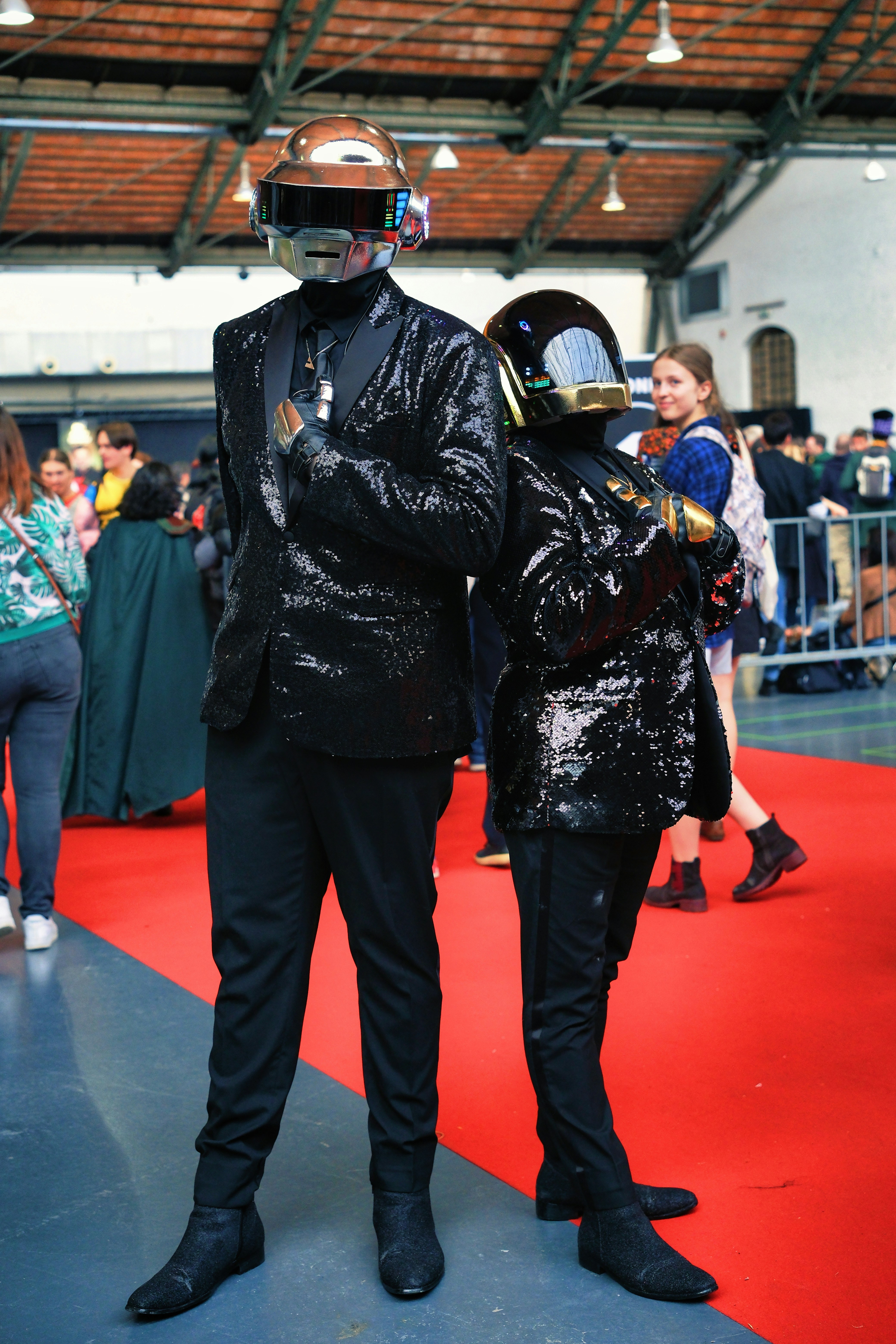 A man in a suit and helmet standing next to a woman