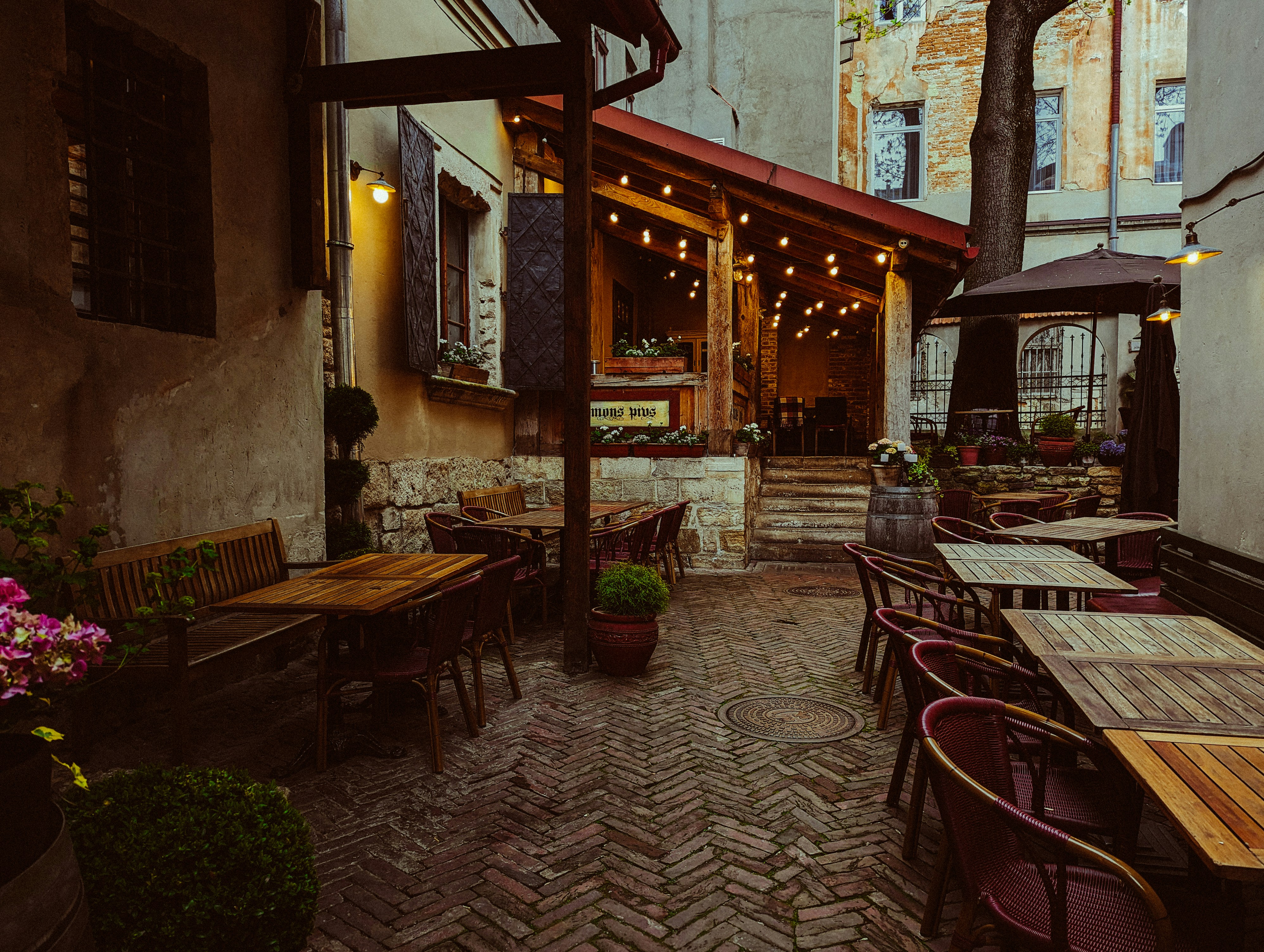 Eine Außenterrasse mit Tischen und Sonnenschirmen