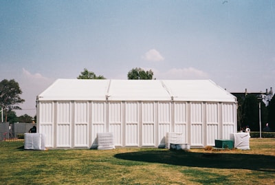A large white building sitting on top of a lush green field