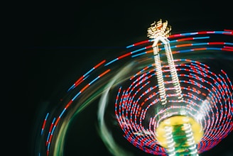 A ferris wheel spinning at night with a blurry background