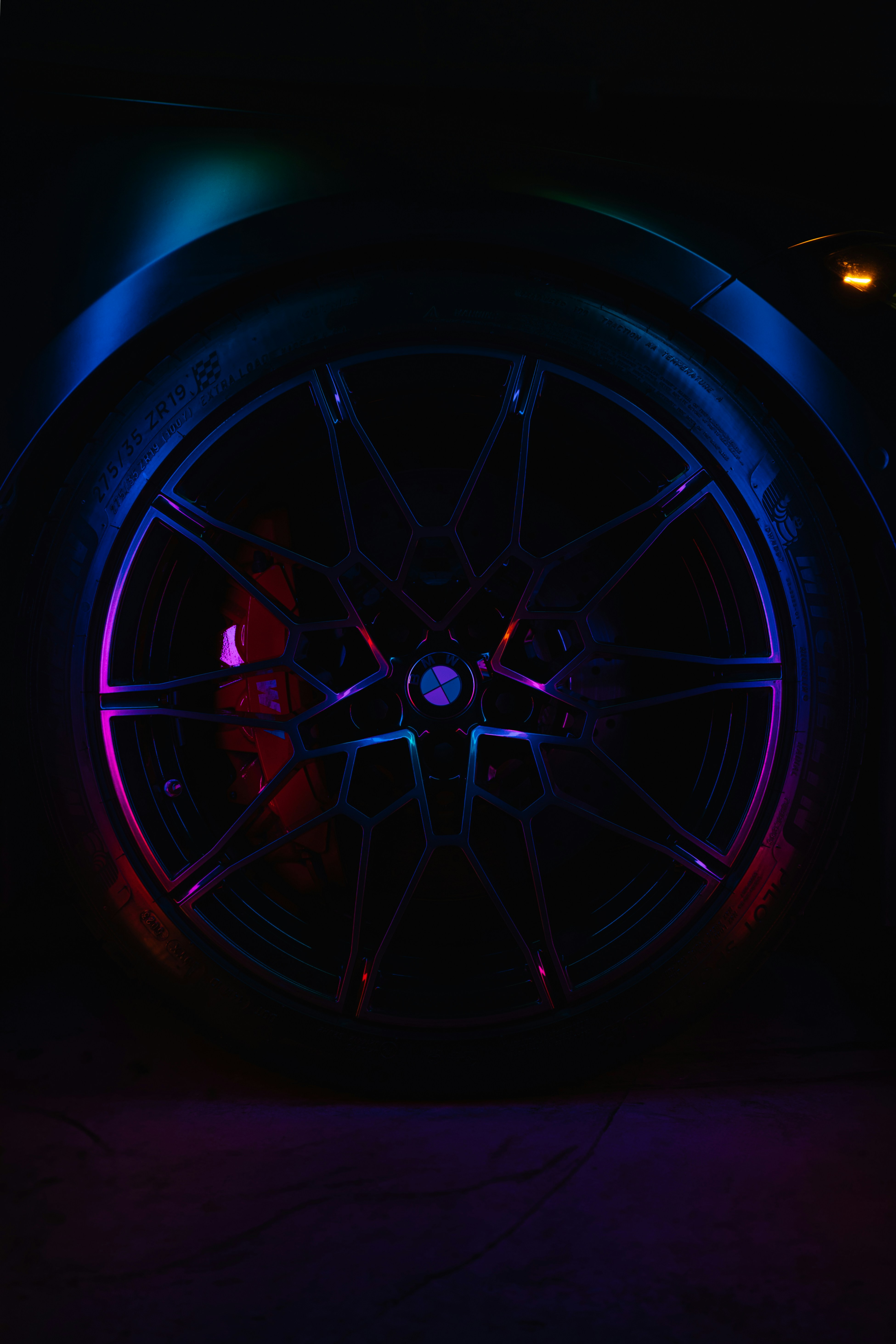 A close up of a wheel on a car in the dark