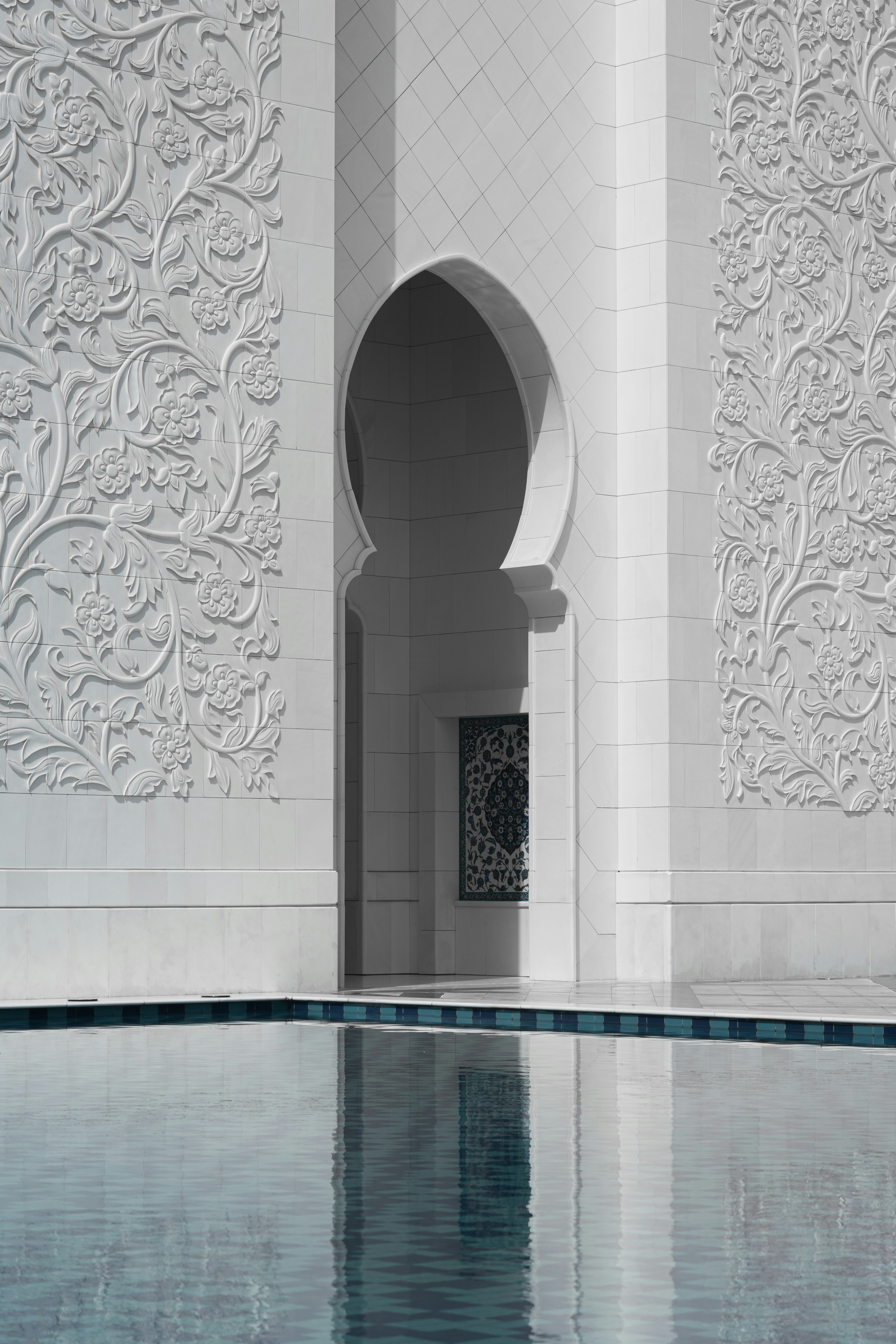 A pool in a large building with a white wall