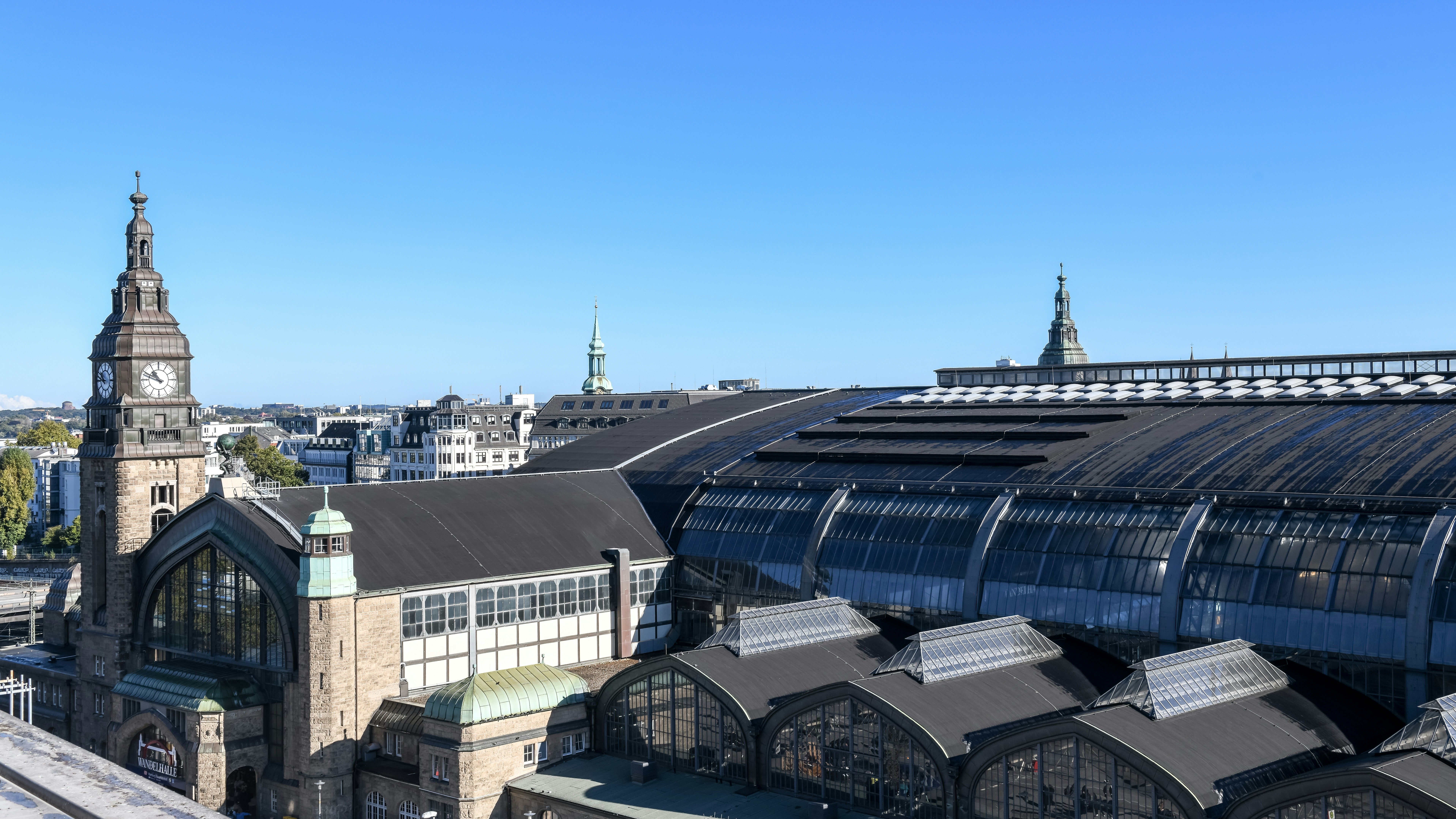 An aerial view of a train station with a clock tower in the background