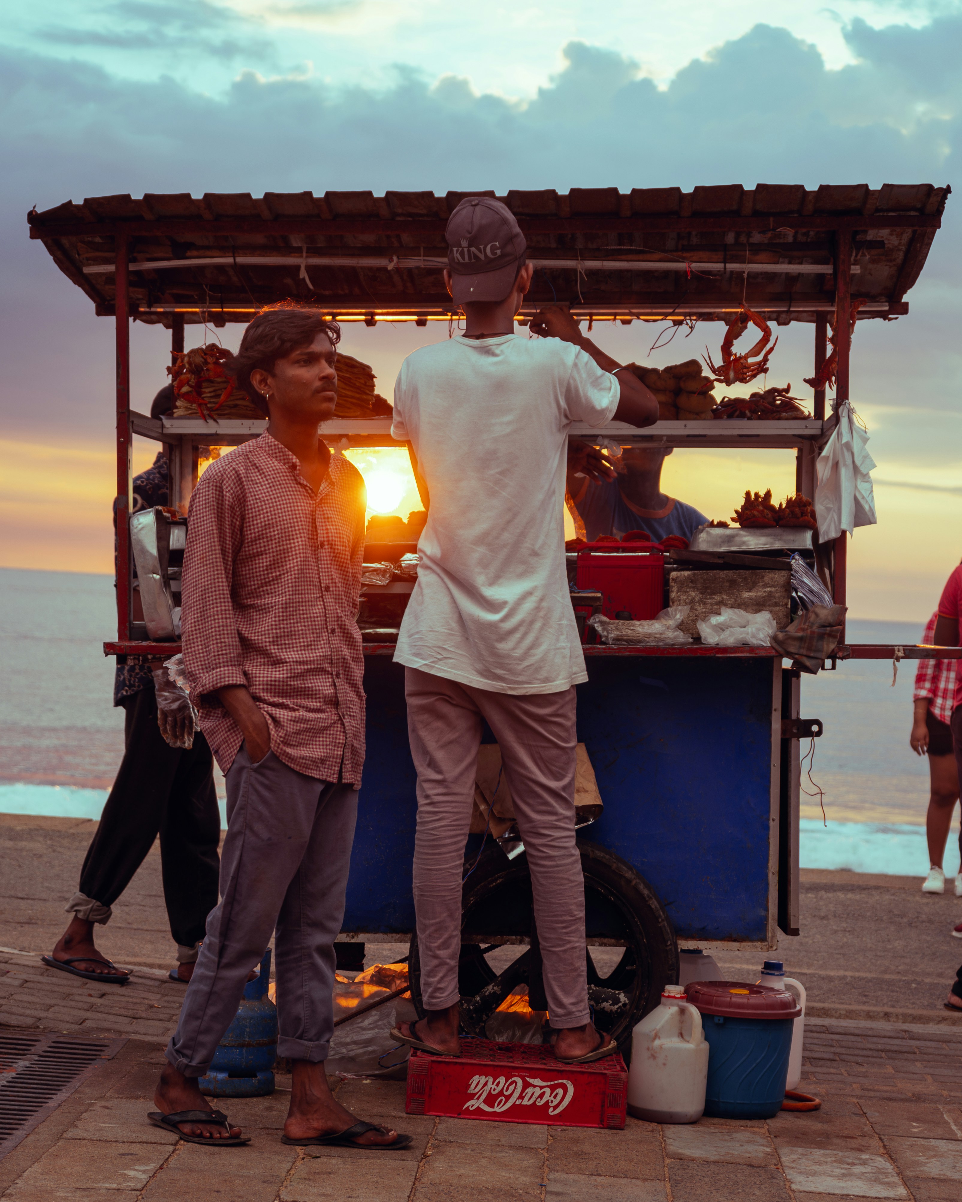 A group of people standing around a food cart